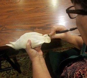 Michelle is etching in feather detail on a meadowlark carving. 